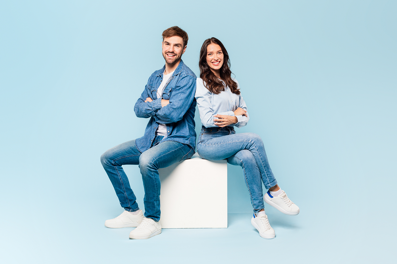 Frau und Mann sitzen auf einem Hocker. Sie sind froh, dass sie gerade einen Ehevertrag abgeschlossen haben.